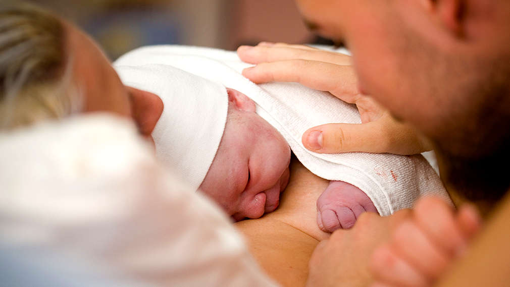 Neugeborenes auf der Brust der Mutter