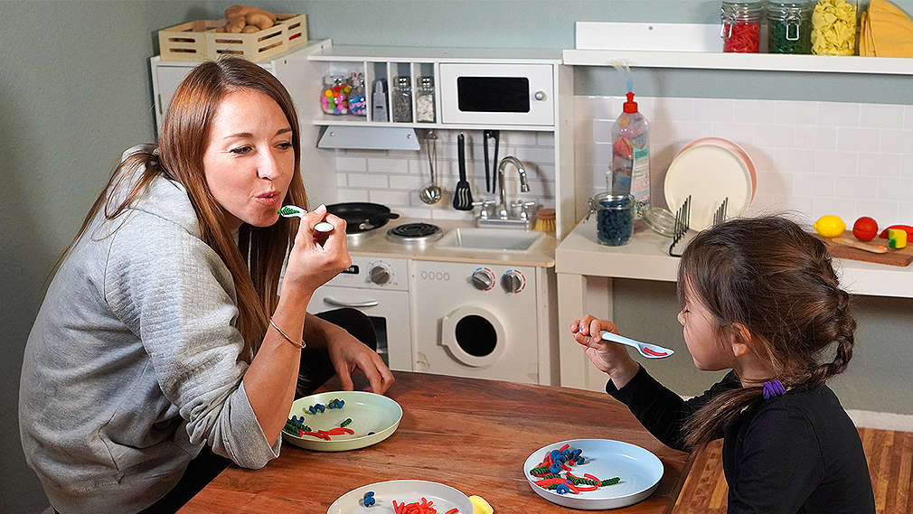 Mutter und Tochter spielen in der Kinderküche