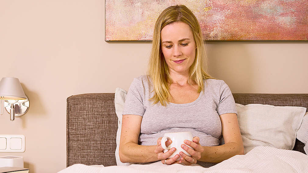 Schwangere Frau entspannt auf dem Sofa