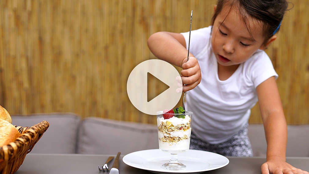 Mädchen isst Müsli am Frühstückstisch