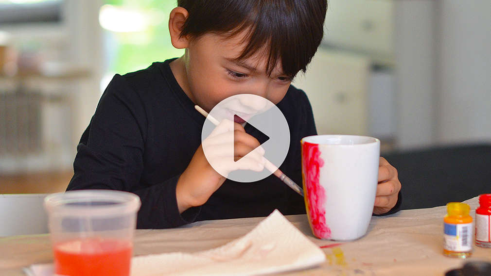 Junge bemalt Trinkbecher