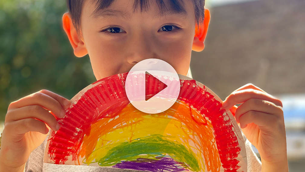 Junge mit selbst gebasteltem Regenbogen