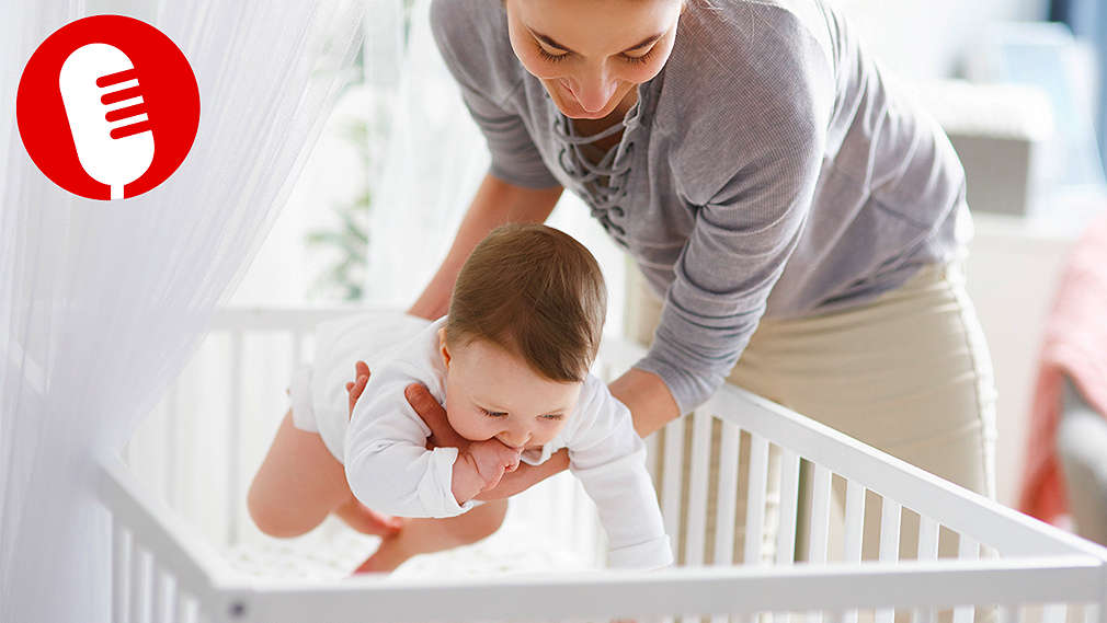 Mutter legt ihr Baby ins Babybett