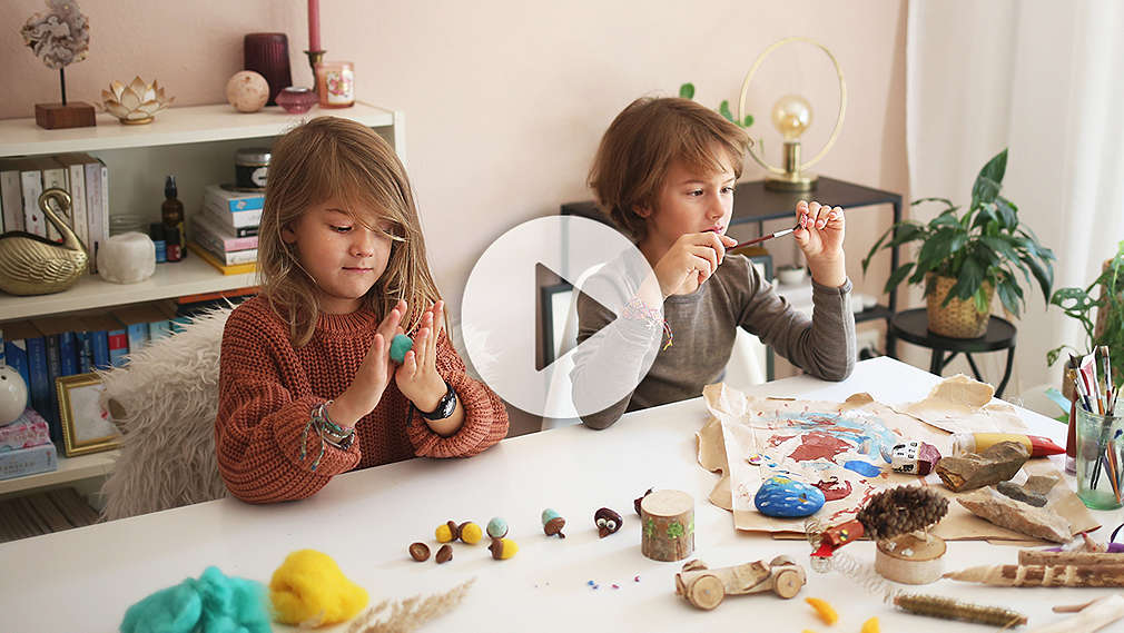 Zwei Kinder sitzen am Tisch und basteln