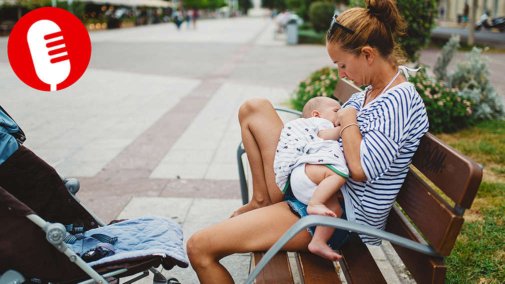 Frau stillt Baby auf einer Parkbank