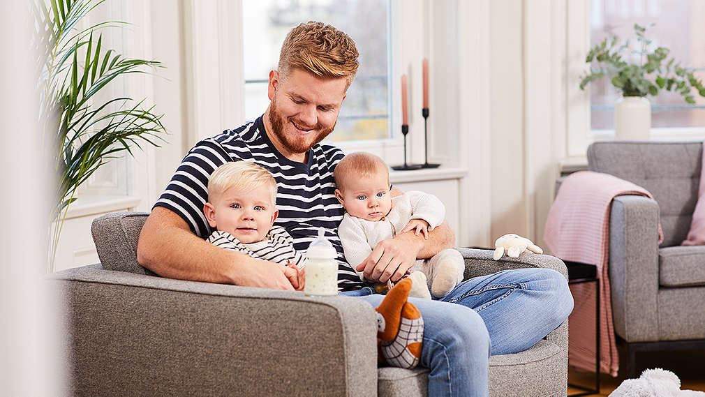 Papa mit zwei Babys im Arm