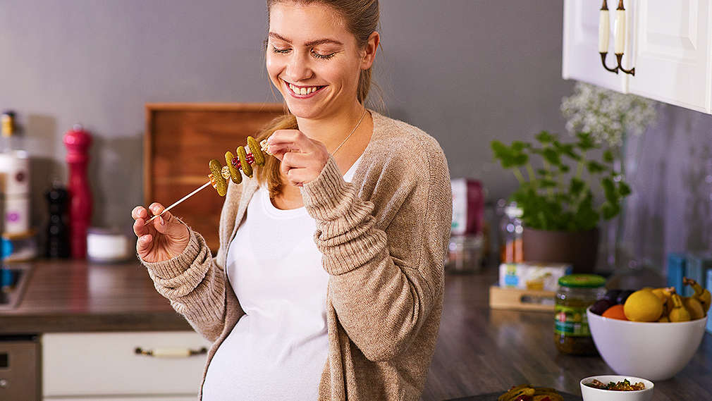Schwangere Frau isst saure Gurken