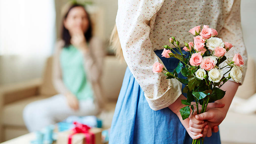 Tochter schenkt Mutter Blumen zum Muttertag