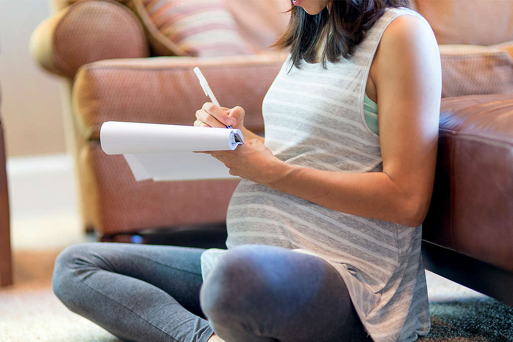 Изображение на корем бременна жена, която прави списък
