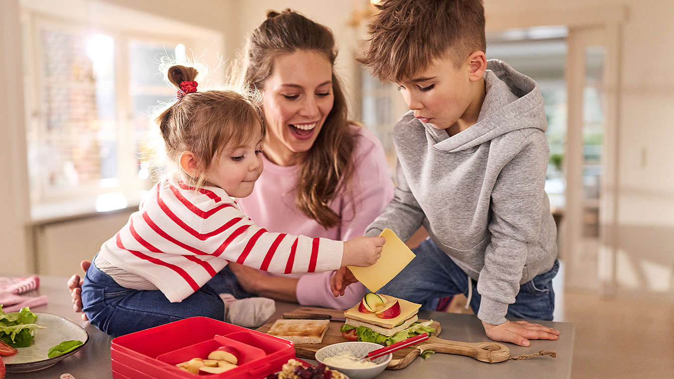 Mutter mit zwei Kindern am Frühstückstisch