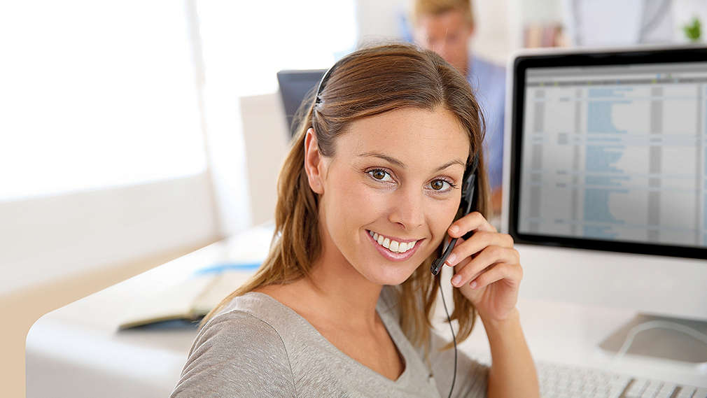 Mladá žena přijímá telefonáty od zákazníků