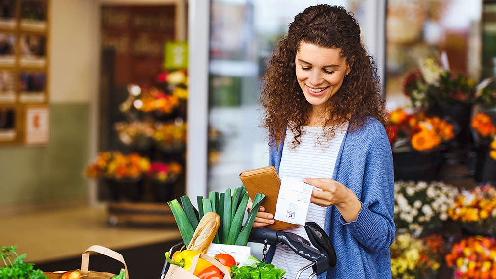 Žena si kontroluje účtenku k nákupu