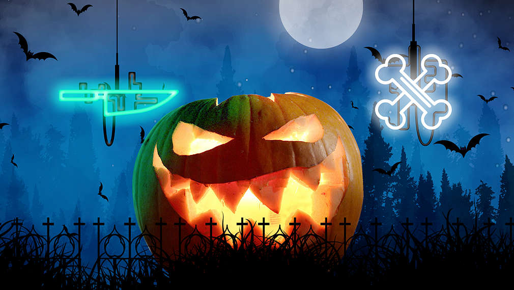 Beleuchtete Kürbisfratze mit Totenkopf und Kerzen