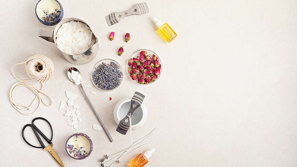 Unterschiedliche Utensilien und Zutaten zur Seifenherstellung, wie Rosen- und Lavendelblüten sowie unterschiedliche Öle