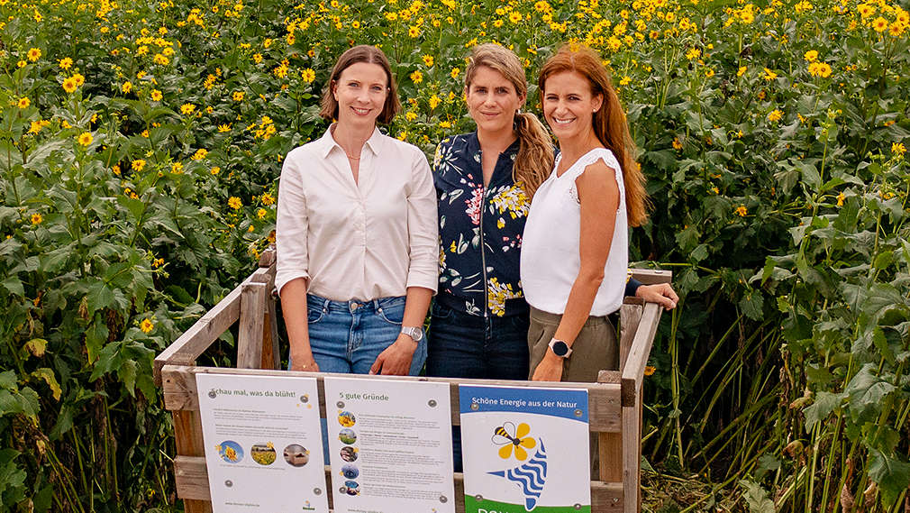 Moderatorin Janine Utsch mit Rabea von OutNature und Elisa von Kaufland vor einem Feld mit Silphie-Pflanzen