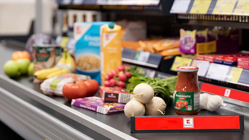 Zu sehen ist ein Kassenband in einer Kaufland-Filiale, auf dem viele Einkäufe liegen