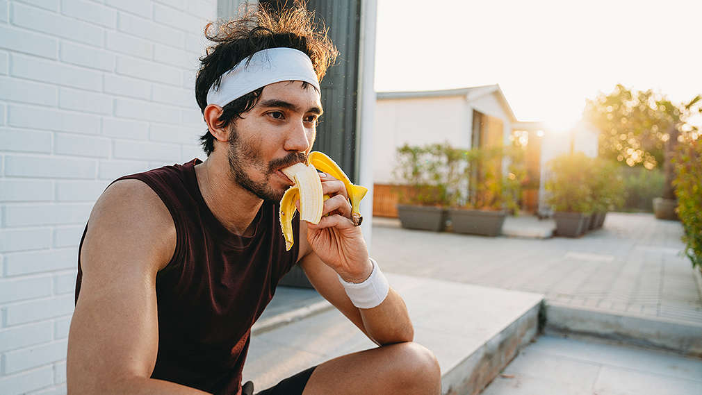 Eine Frau isst nach dem Sport eine Banane