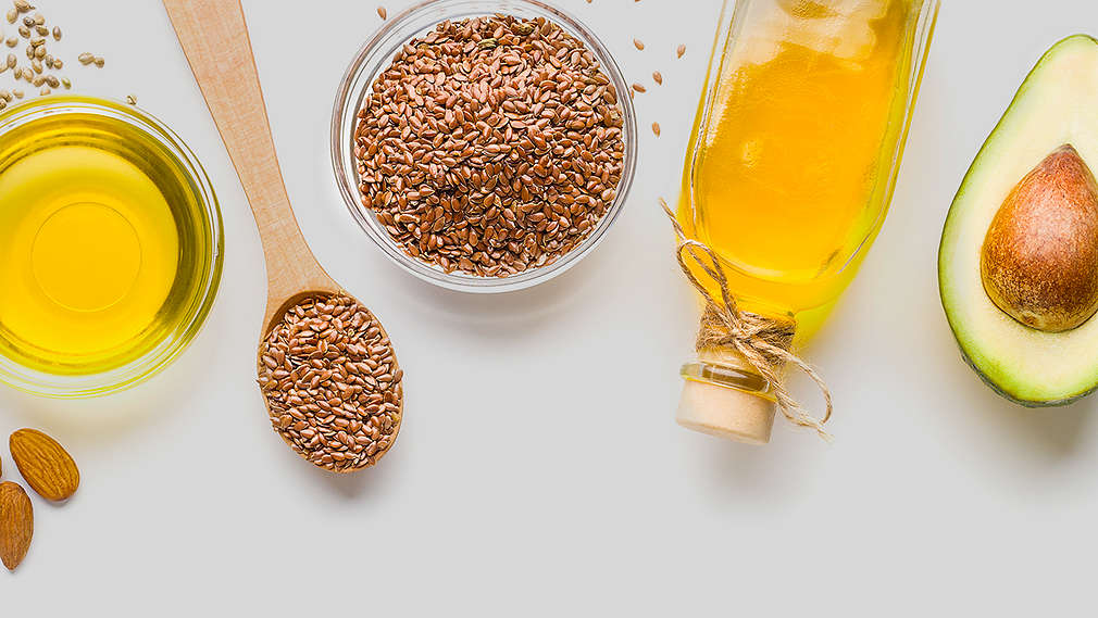 Verschiedene Öle und deren Basis in unterschiedlichen Behältern: Avocado, Mandeln, Leinsamen
