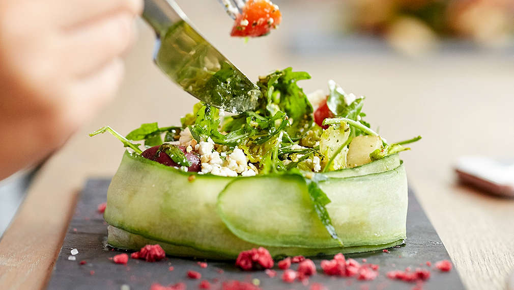 Verschiedenes Gemüse ist in einer dünnen Gurkenscheibe gewickelt