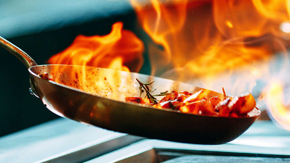 Fleisch wird in einer Pfanne flambiert