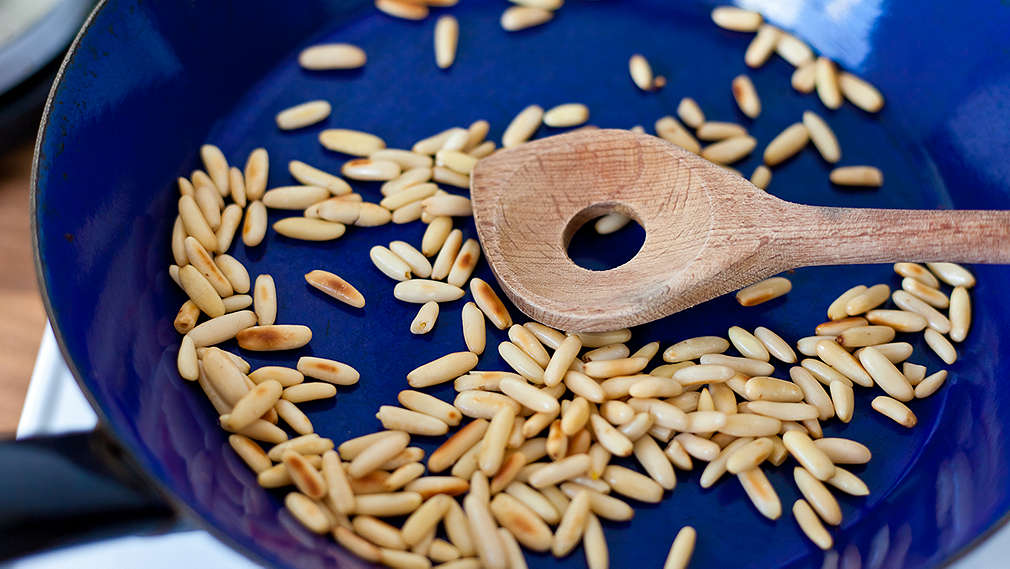 Pinienkerne werden in einer Pfanne angeröstet