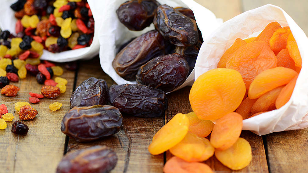 Gedörrtes Obst in weißen Papiertütchen angerichtet