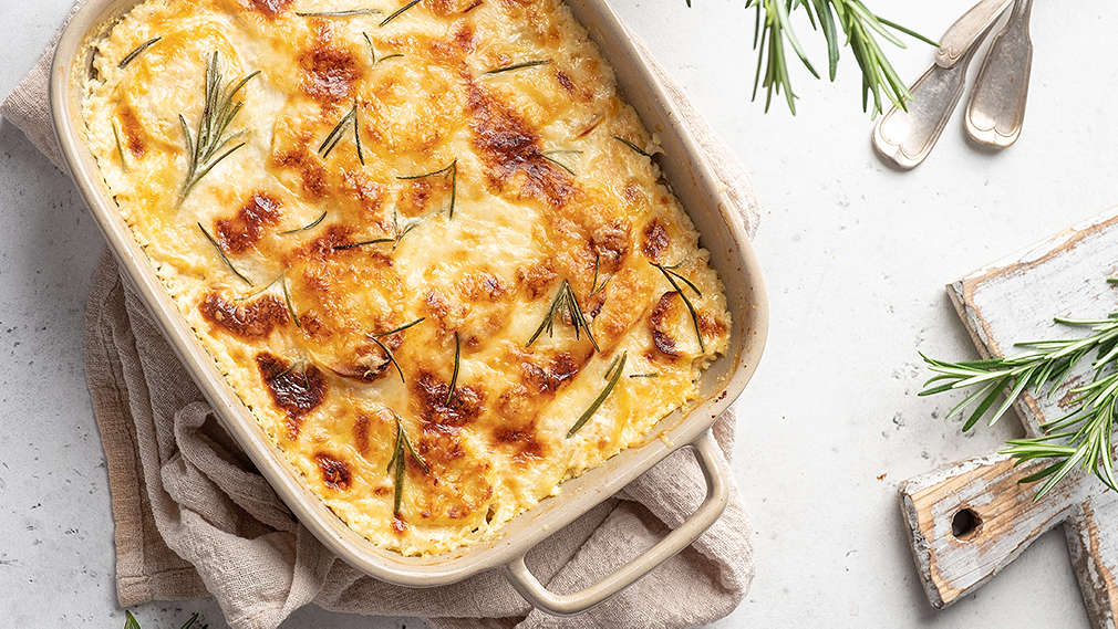 Gratin in Auflaufform dekoriert mit frischem Rosmarin