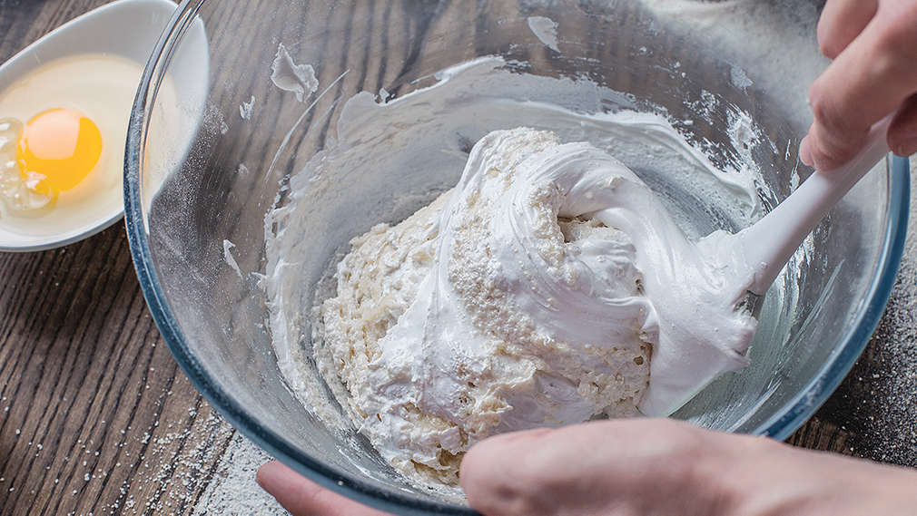 Eischnee wird behutsam unter Mehl gemischt