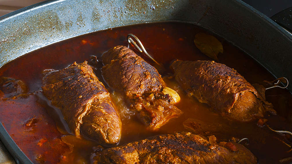 Mehrere Fleischstücke werden in einer Bratpfanne geschmort 