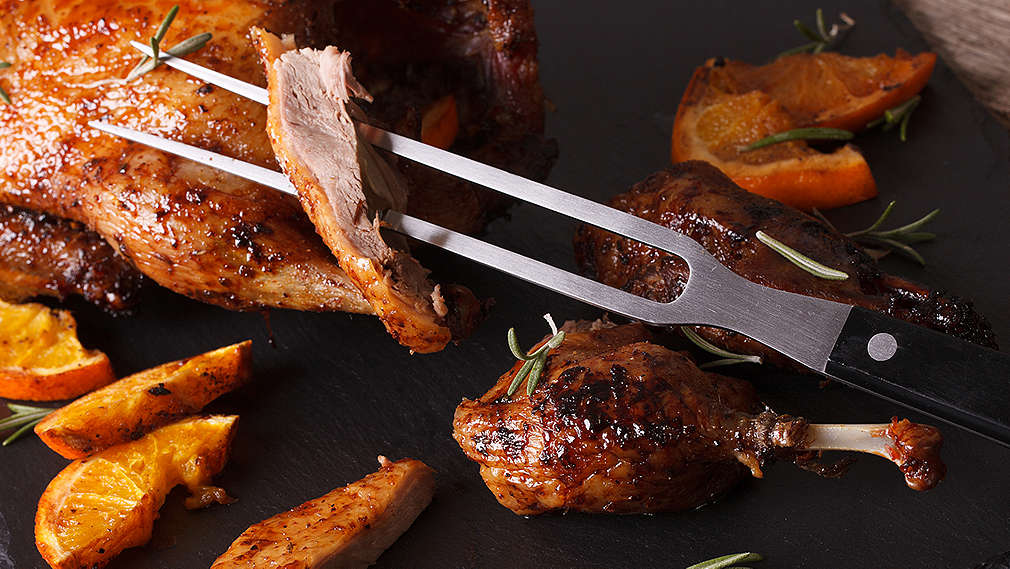 Ein Stück vom tranchierten Hühnchen auf einer Tranchiergabel