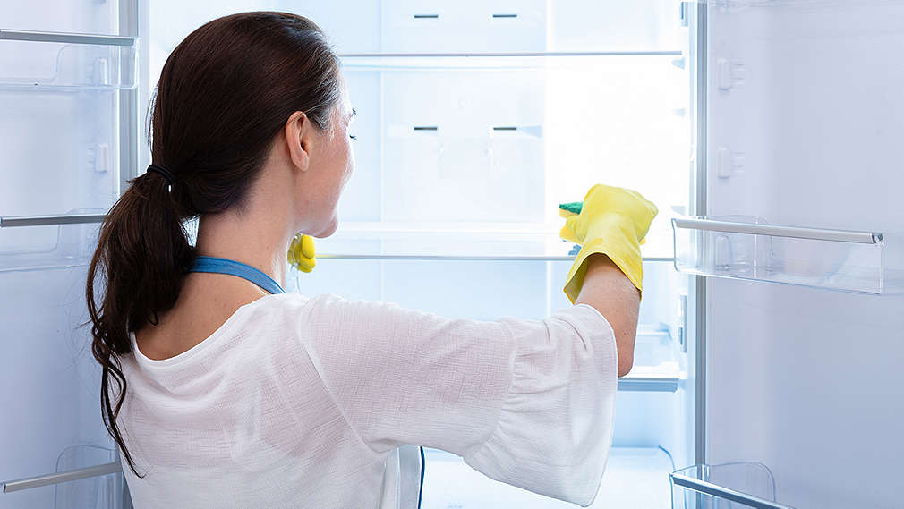 Frau reinigt Kühlschrank