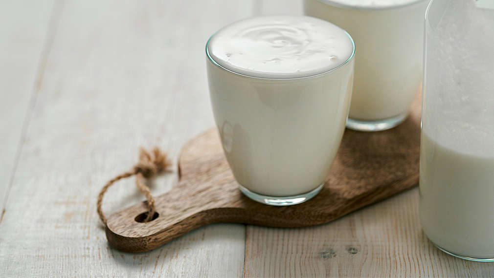 Zu sehen sind zwei Gläser mit Dickmilch und eine Glaskanne. 