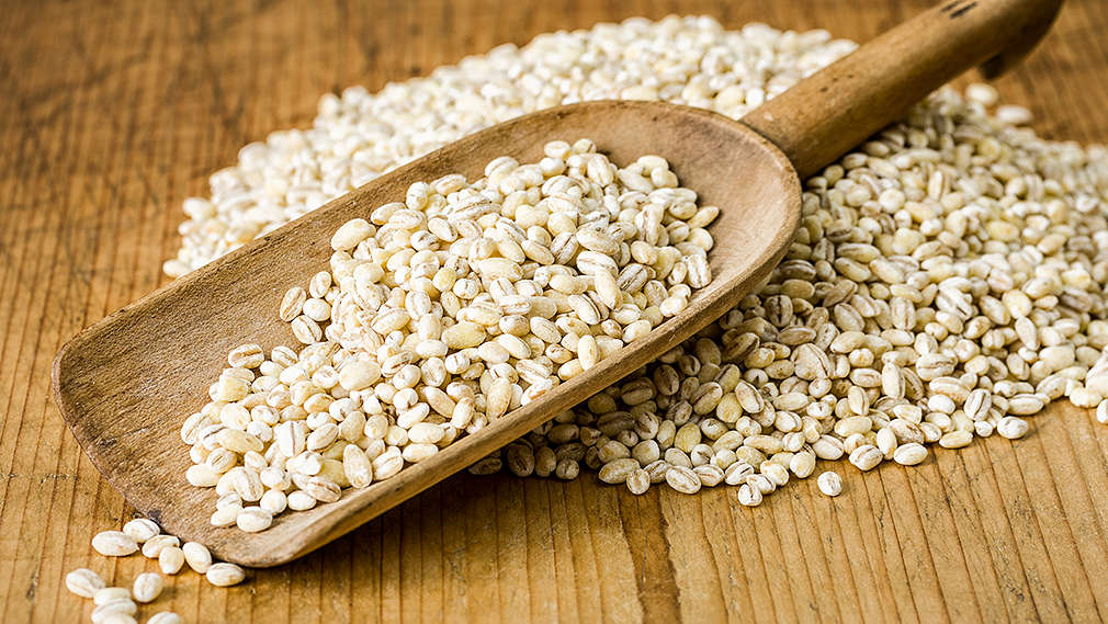 Zu sehen ist eine Schaufel mit Graupen auf einem Holztisch