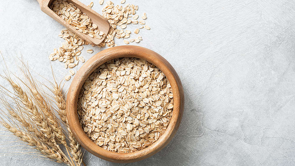 Hafer in einer braunen Schüssel auf grauem Untergrund