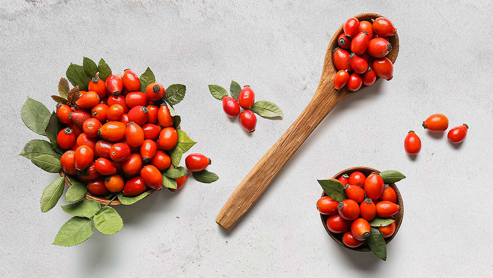 Hagebutten auf einem Löffel und in Schalen.