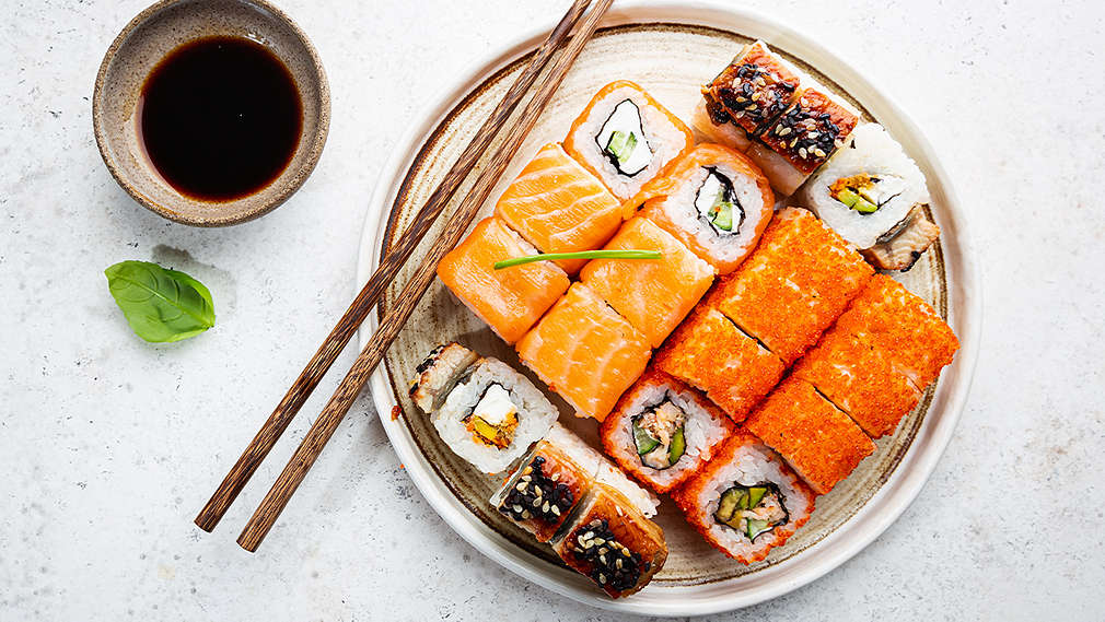 Sushi, die mit Essstäbchen gegessen werden