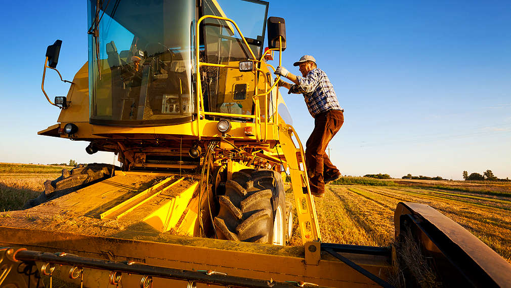 Muž s kombajnem na poli