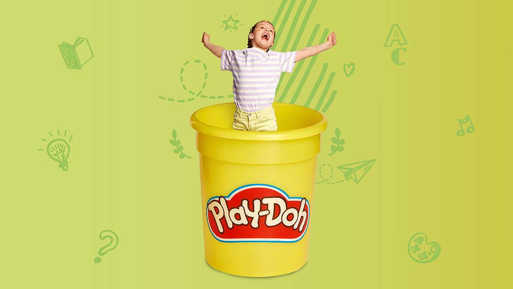 Schulkind hupft aus einer Play-Doh-Dose