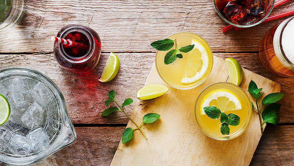 Verschiedene kühle Getränke dekoriert mit Minzblättern und Limetten