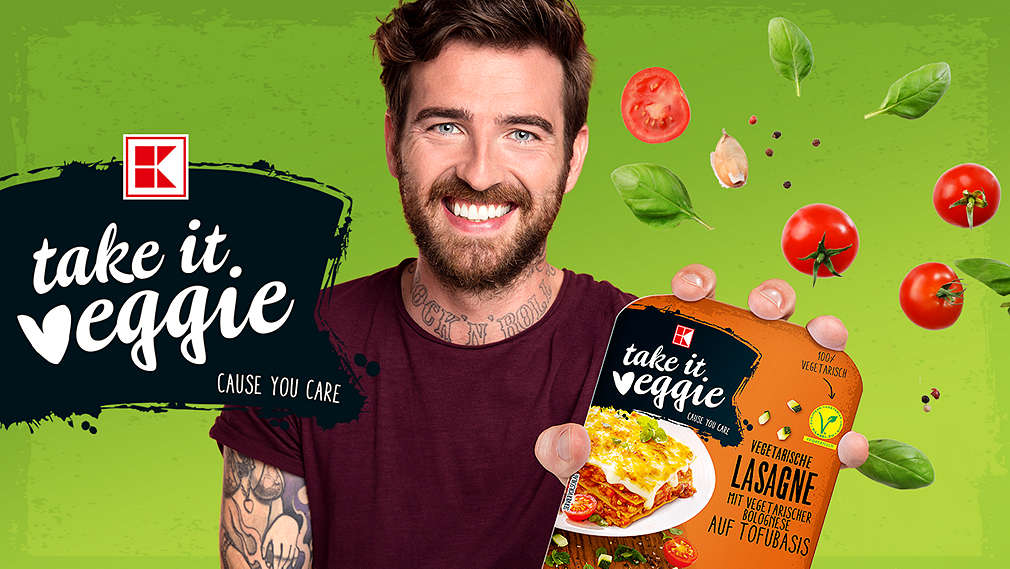 Mann mit einer Lasagne von K-take it veggie in der Hand