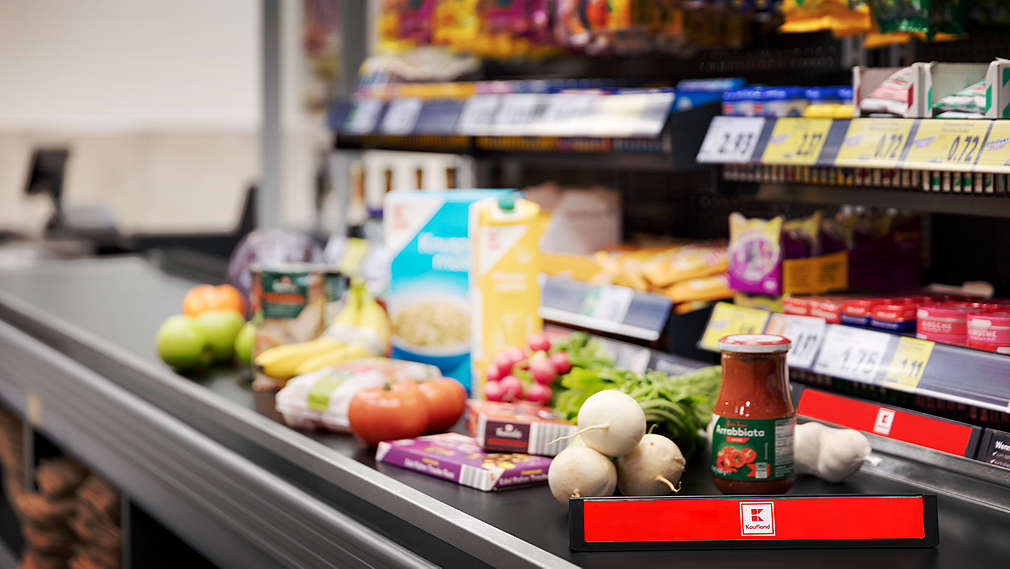 Na obrázku je pokladní pás v prodejně Kaufland se spoustou nákupů.