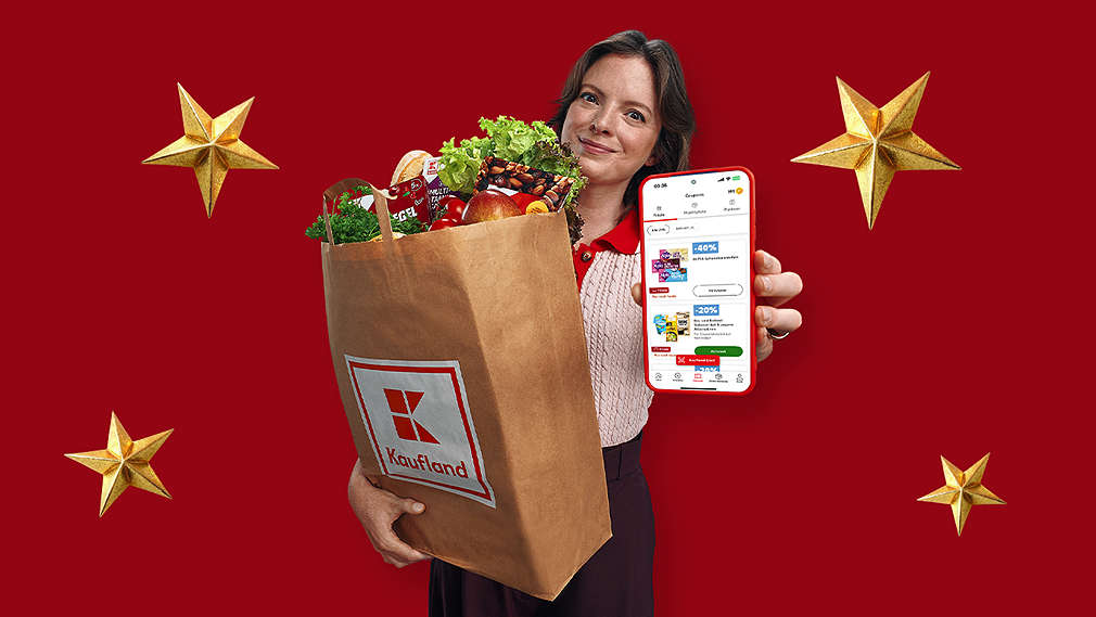 Kobieta trzyma torbę z zakupami i telefon w ręce